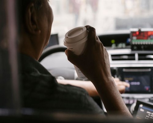 Person taking a break with coffee during morning commute