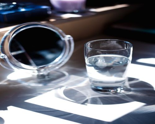 Glass of water near a window with sunlight